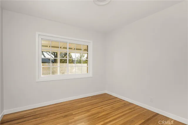 an empty room with wooden floor and a window