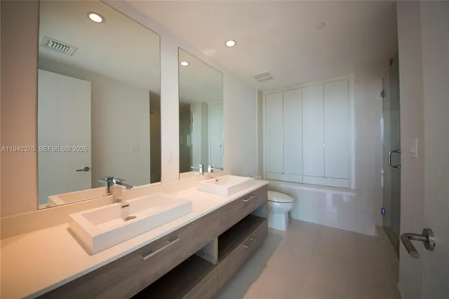 a spacious bathroom with a double vanity sink and mirror