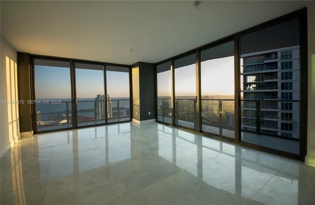a view of an empty room with windows and a balcony
