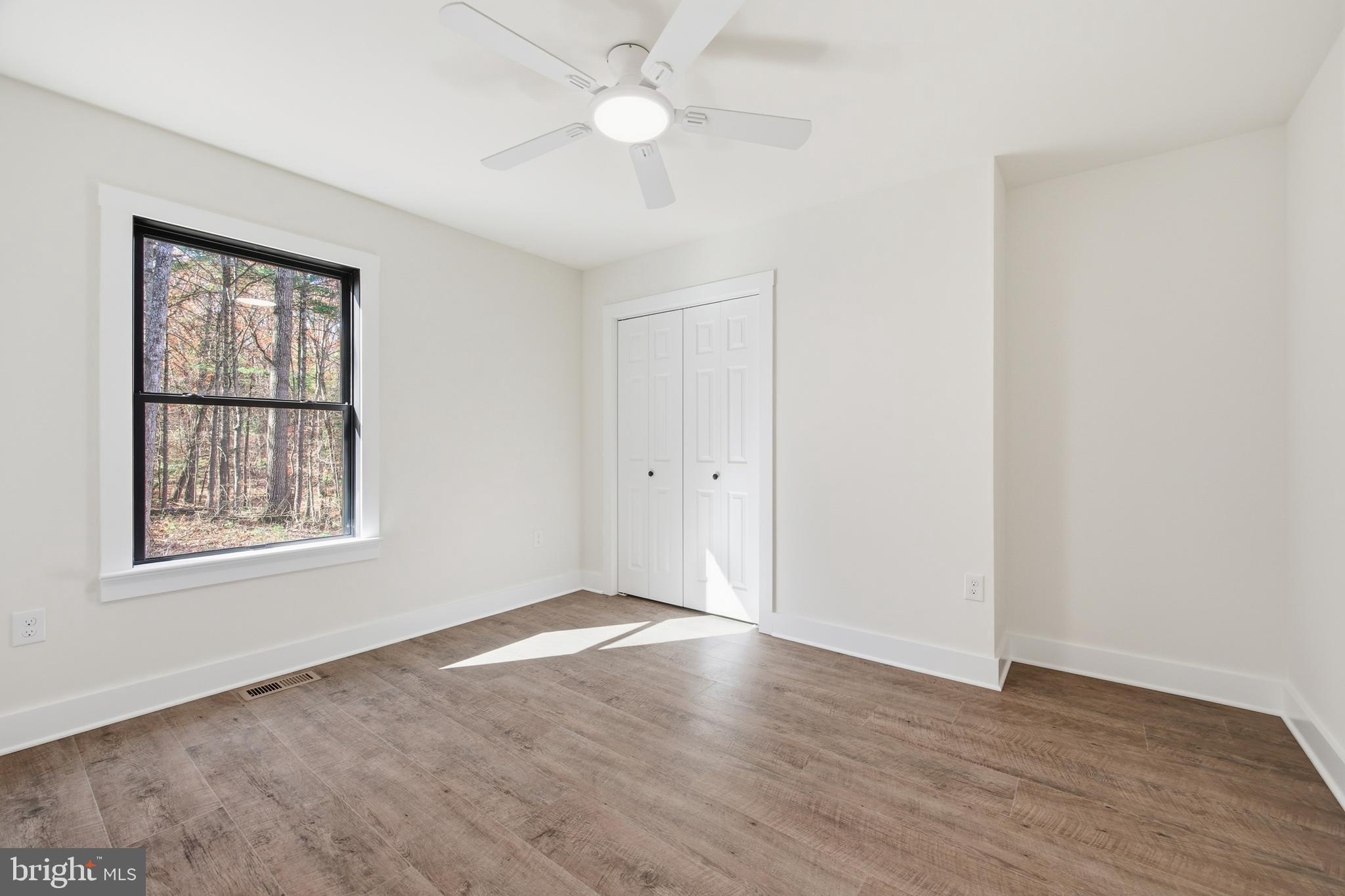 125 Crabapple Road Mount Jackson, VA 22842 - Photo 31 of 51 an empty room with wooden floor chandelier fan and windows