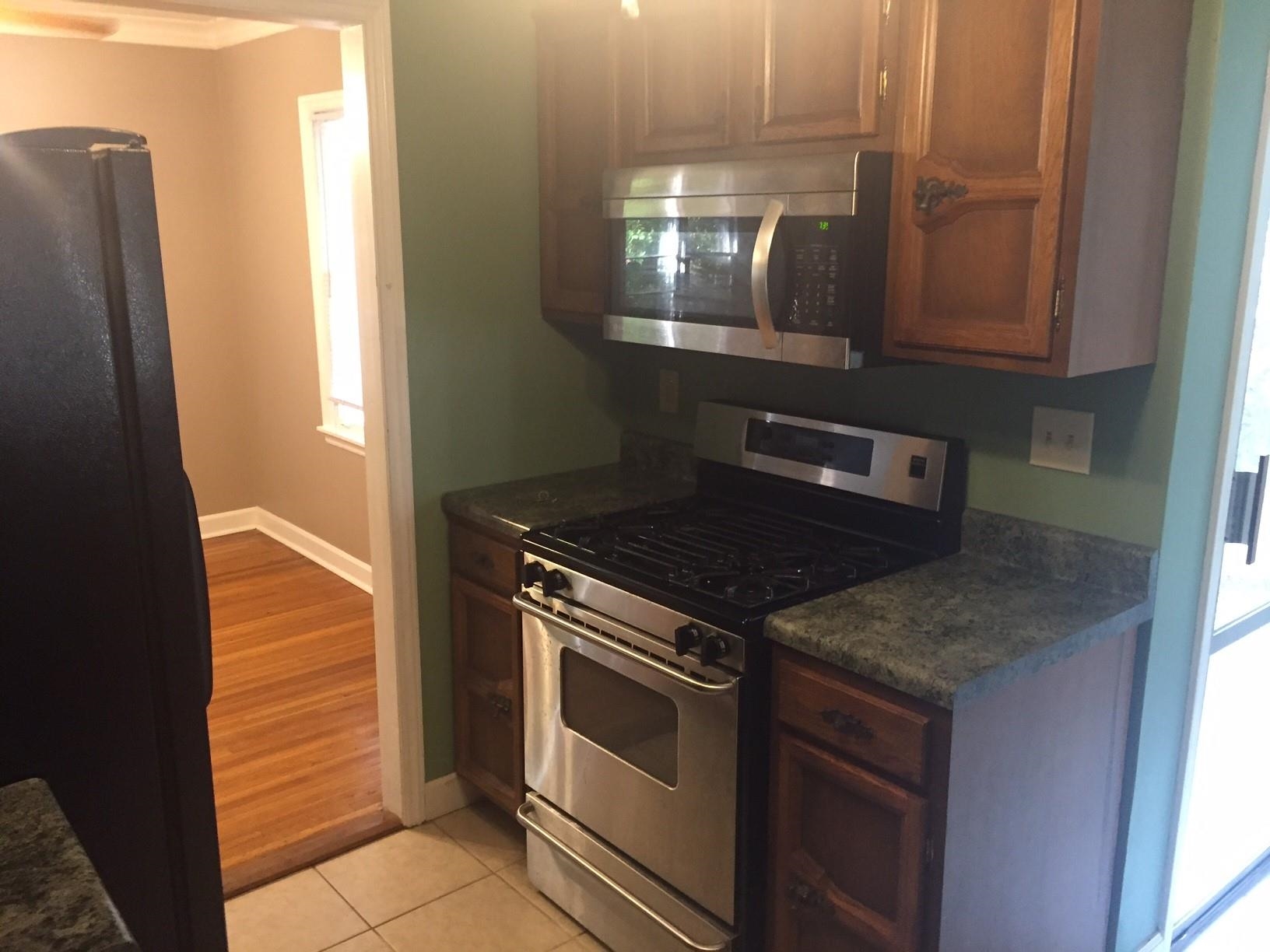 4573 Boyce Road Memphis, TN 38117 - Photo 4 of 18 a kitchen with granite countertop a stove and a microwave