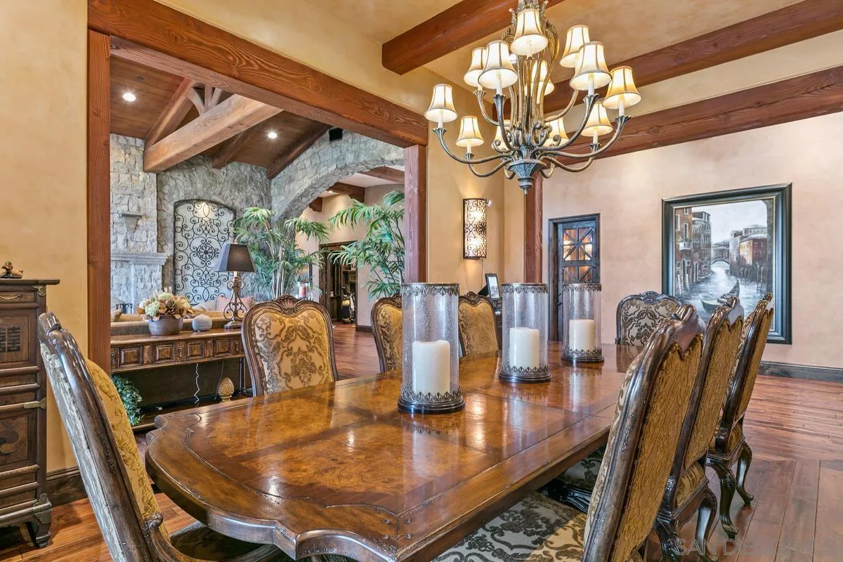 6934 St Andrews Road Rancho Santa Fe, CA 92067 - Photo 12 of 49 a dining room with wooden floor a chandelier a wooden table and chairs