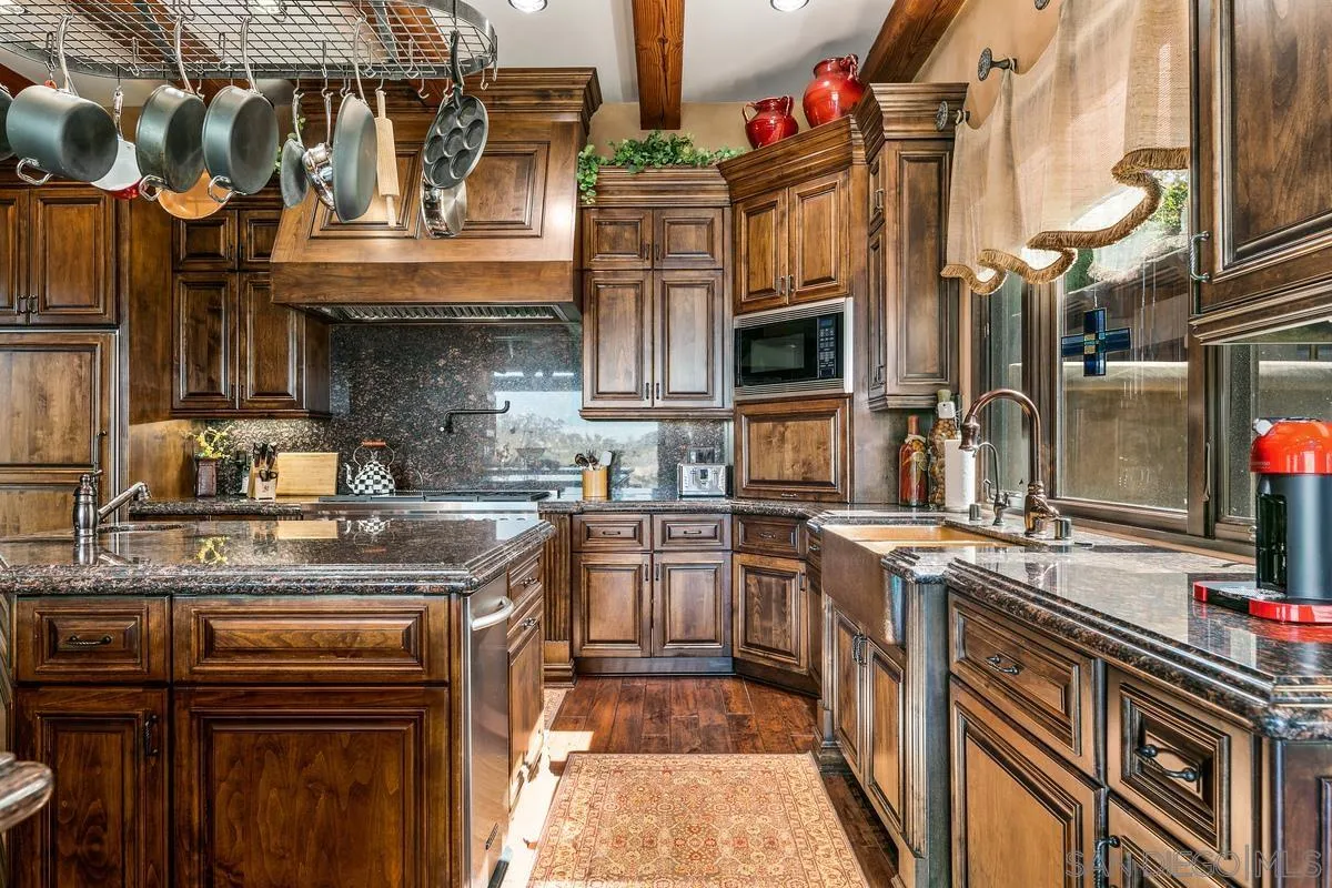 6934 St Andrews Road Rancho Santa Fe, CA 92067 - Photo 18 of 49 a kitchen with stainless steel appliances granite countertop a stove and cabinets