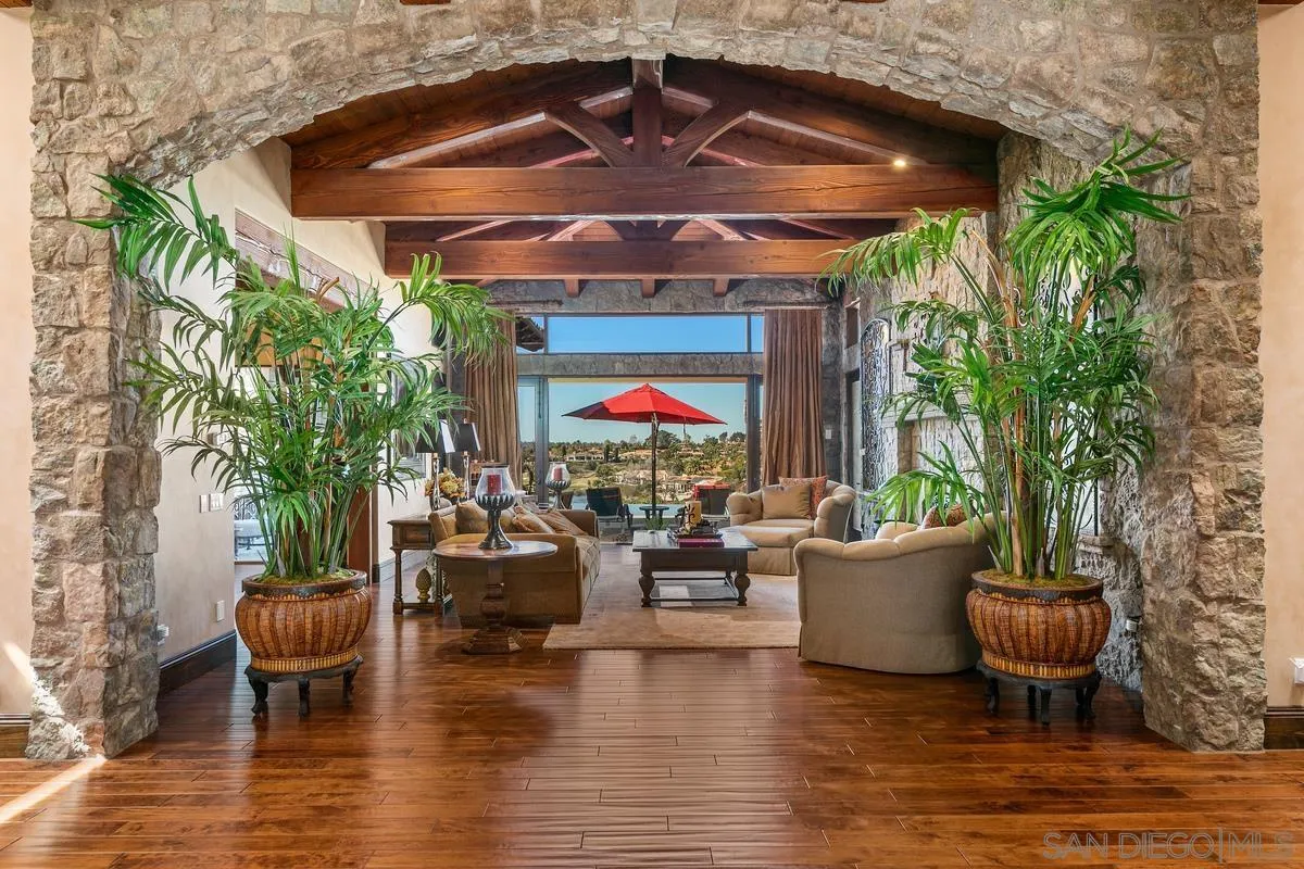 6934 St Andrews Road Rancho Santa Fe, CA 92067 - Photo 7 of 49 a view of a patio with table and chairs potted plants and a large tree
