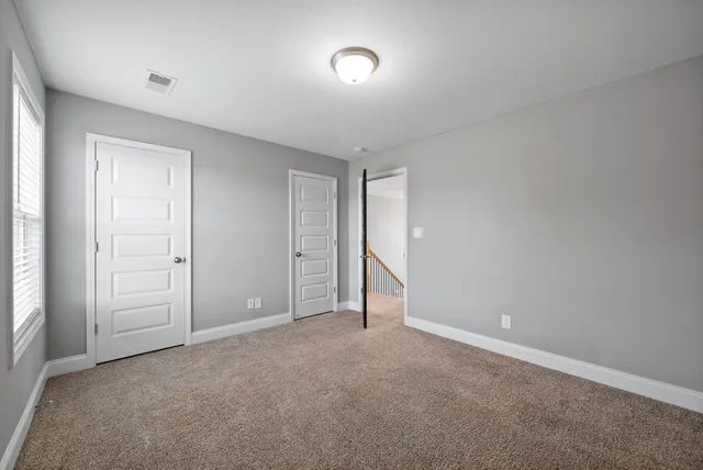 an empty room with a ceiling fan and a window