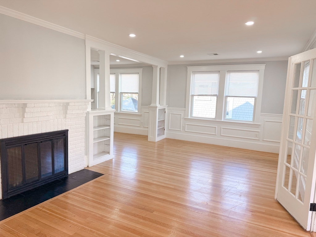 41 Pond Street, Unit 1 Framingham, MA 01702 - Photo 3 of 15 a view of an empty room with wooden floor and a window