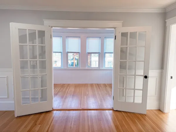 an empty room with wooden floor and windows