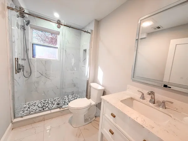 a bathroom with a sink a toilet and shower