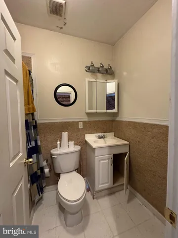 a white toilet sitting next to a bathroom sink and tub