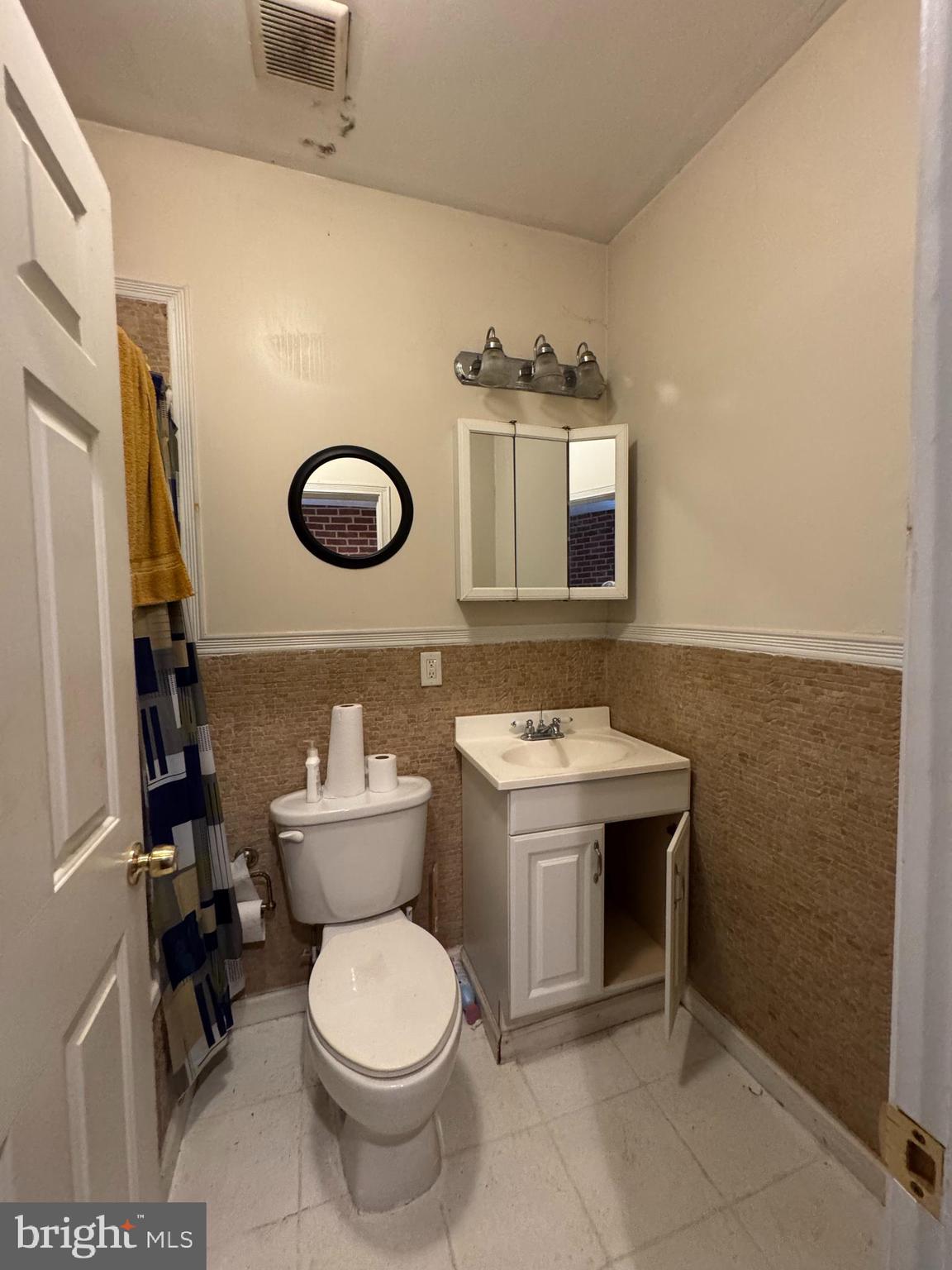 200 South Parrish Street Baltimore, MD 21223 - Photo 6 of 21 a bathroom with a toilet sink vanity and mirror