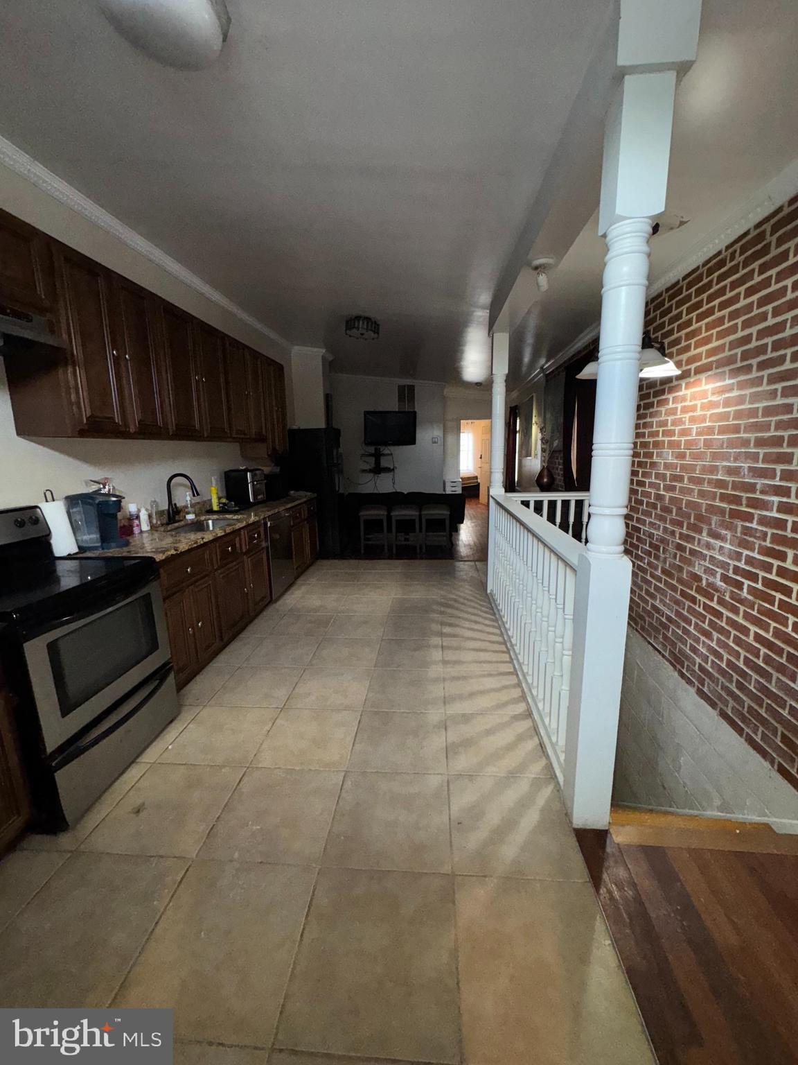 200 South Parrish Street Baltimore, MD 21223 - Photo 8 of 21 a kitchen with granite countertop a refrigerator and a stove top oven