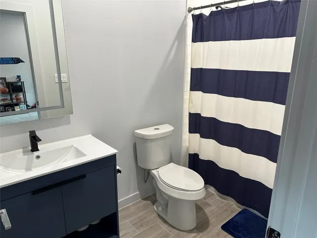 a bathroom with a sink a toilet a shower and a mirror