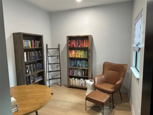 a bedroom with a book shelf and a chair