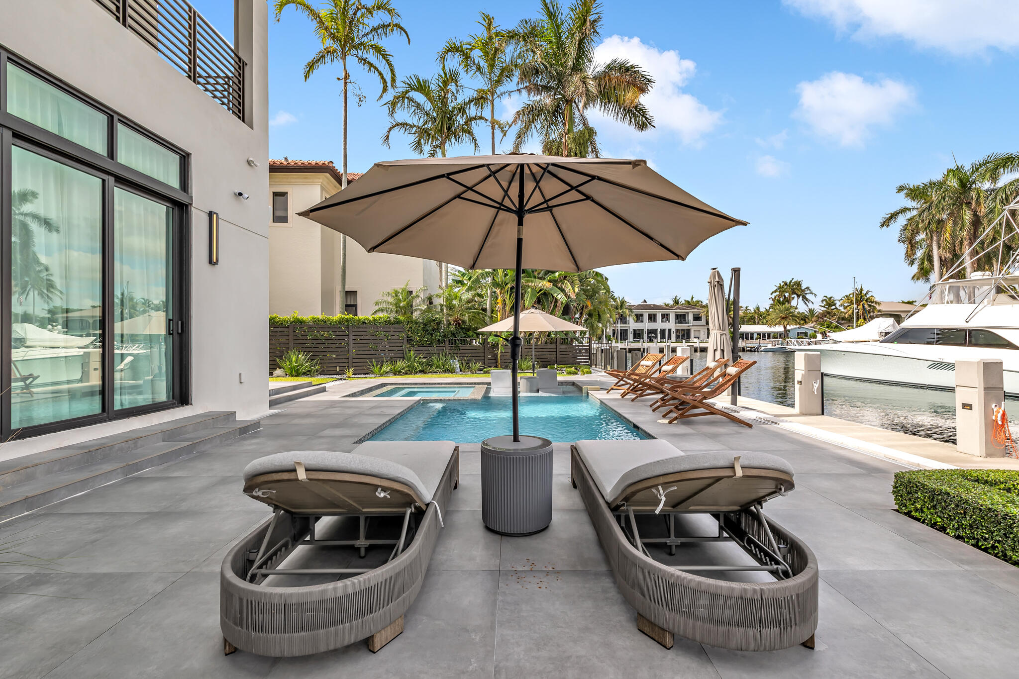 3711 Northeast 30th Avenue Lighthouse Point, FL 33064 - Photo 33 of 57 a view of a patio with couches table and chairs under an umbrella