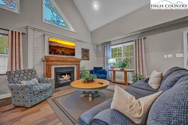 a living room with furniture a fireplace and a large window