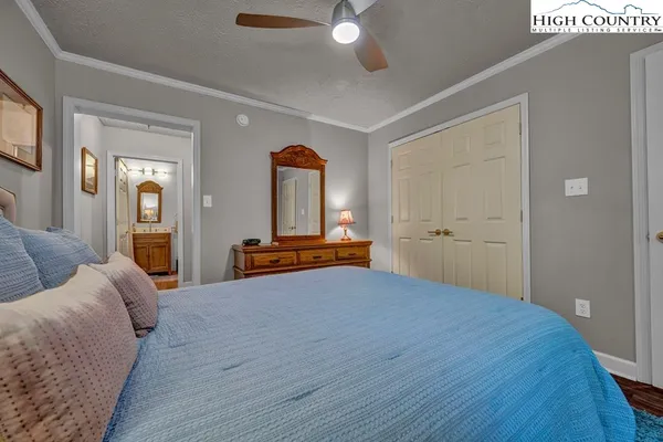 a bedroom with a bed and a large mirror on the dresser