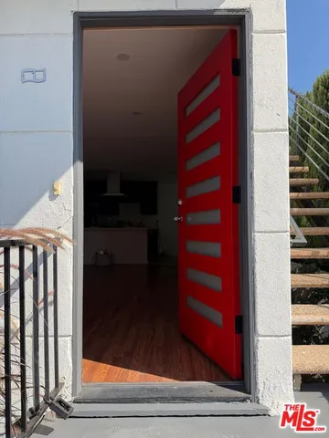 a view of hallway with stairs and wooden floor