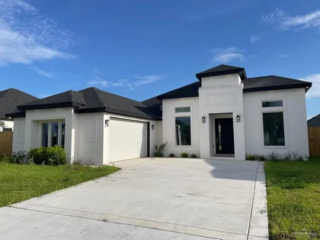 a front view of a house with a yard and garage