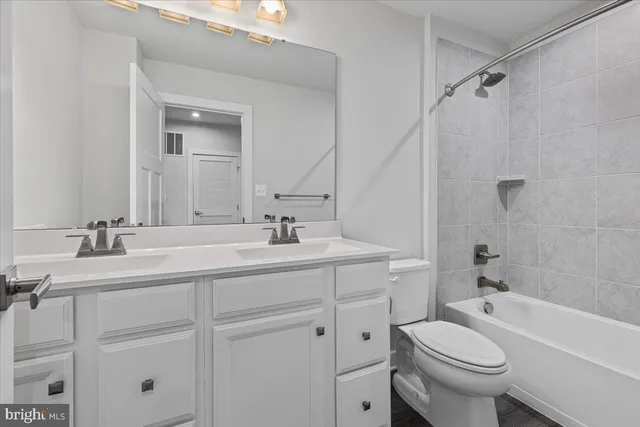 a bathroom with a sink a toilet a mirror a vanity and shower