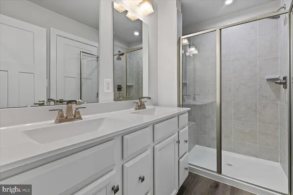 a bathroom with a double vanity sink mirror and shower