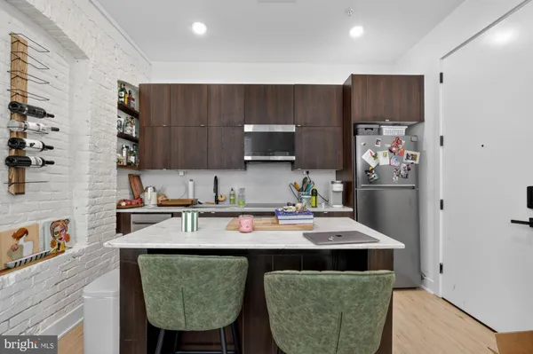 a kitchen with stainless steel appliances granite countertop a refrigerator a sink dishwasher a stove and a microwave