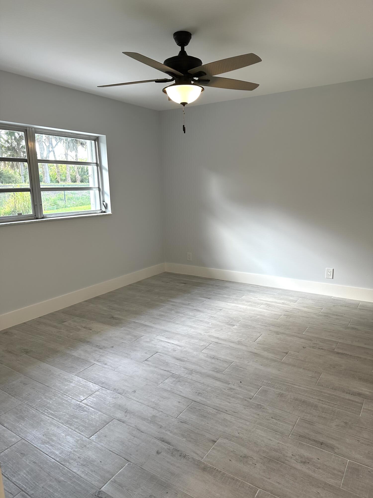 13357 Vía Vesta, Unit B Delray Beach, FL 33484 - Photo 16 of 26 wooden floor in an empty room with a window