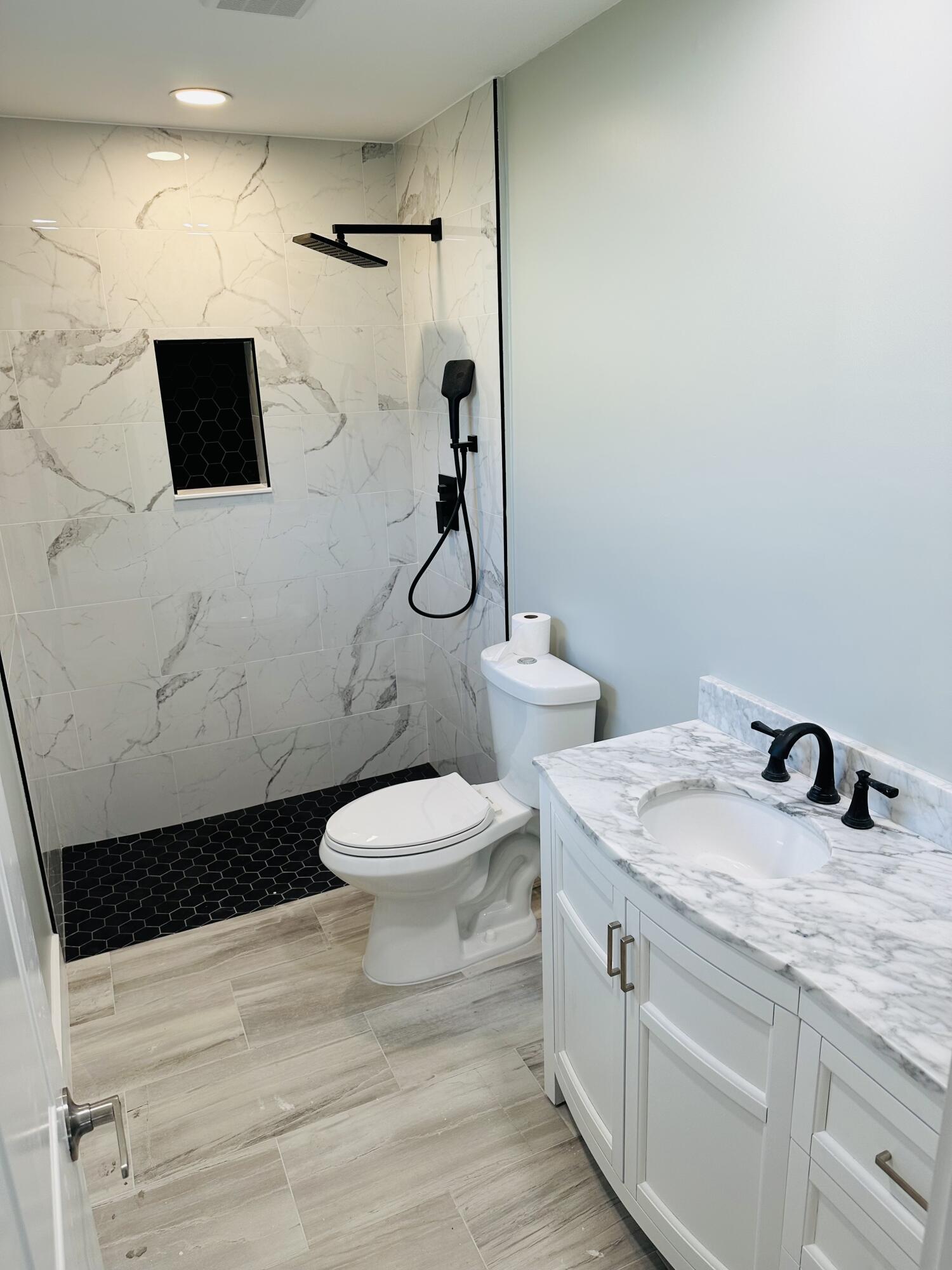 13357 Vía Vesta, Unit B Delray Beach, FL 33484 - Photo 18 of 26 a bathroom with a toilet sink and mirror