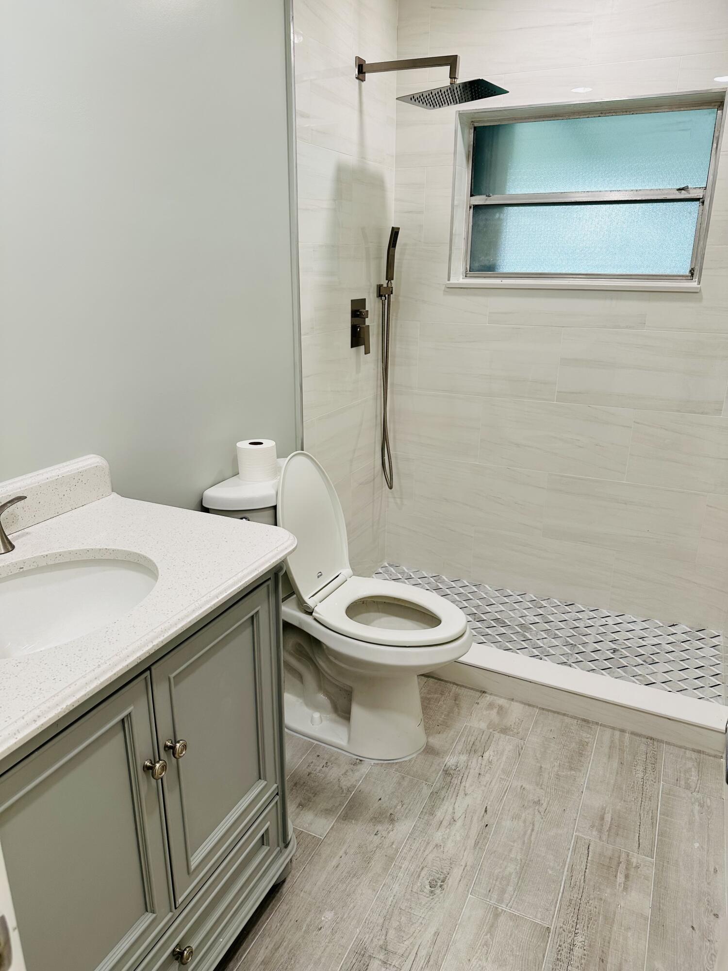 13357 Vía Vesta, Unit B Delray Beach, FL 33484 - Photo 20 of 26 a white toilet sitting next to a bathroom sink