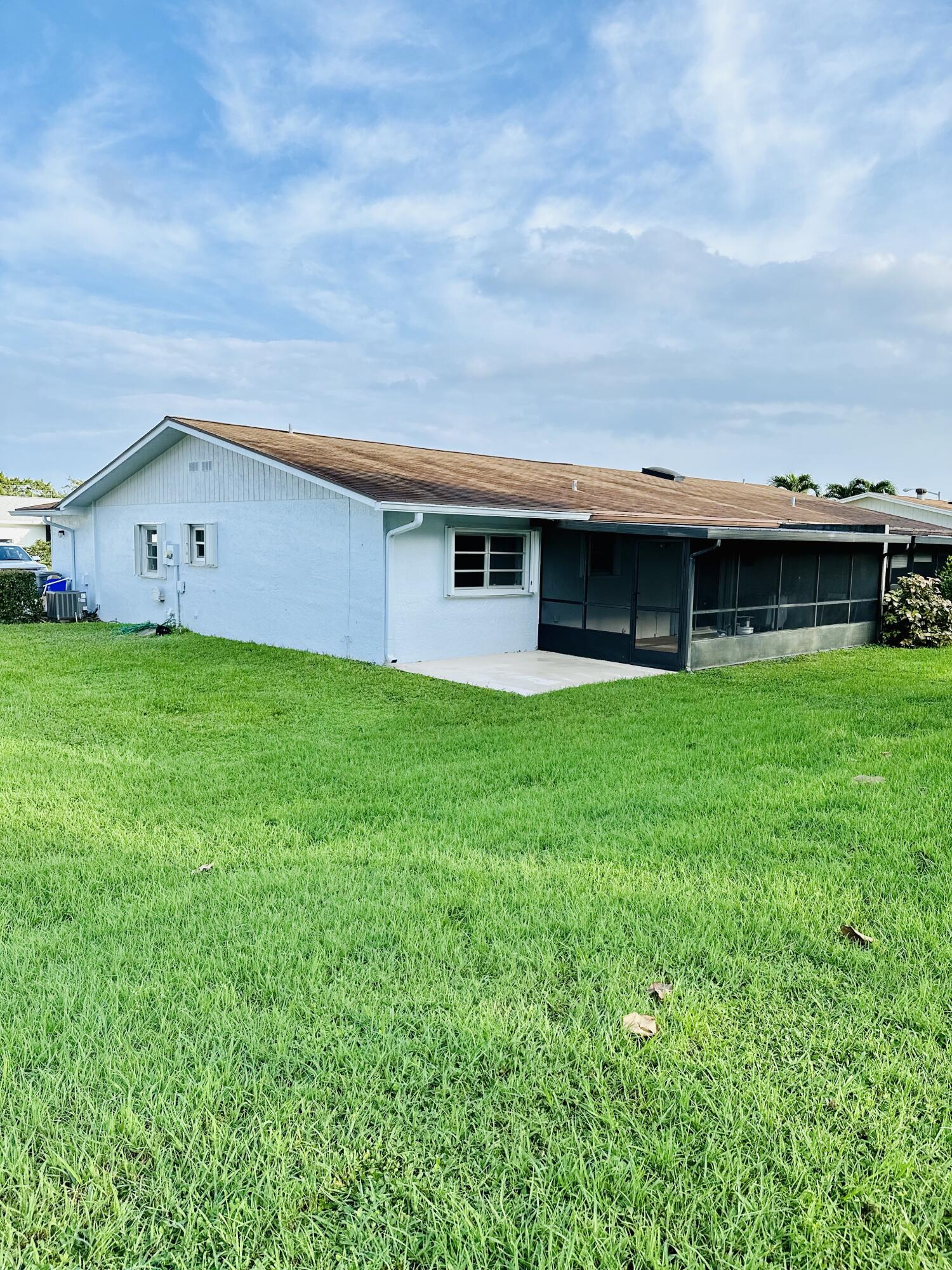 13357 Vía Vesta, Unit B Delray Beach, FL 33484 - Photo 23 of 26 a view of a house with a yard and a large tree