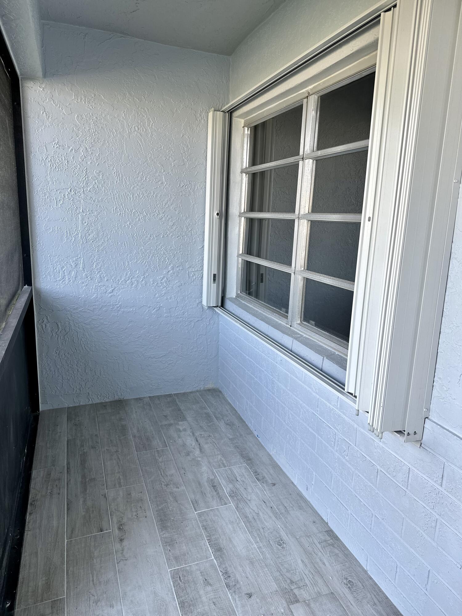 13357 Vía Vesta, Unit B Delray Beach, FL 33484 - Photo 3 of 26 a view of an empty room with wooden floor and a window