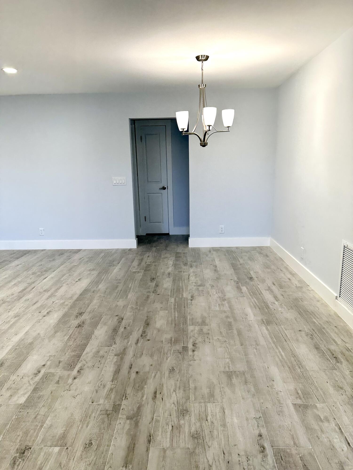 13357 Vía Vesta, Unit B Delray Beach, FL 33484 - Photo 10 of 26 an empty room with a projector and wooden floor