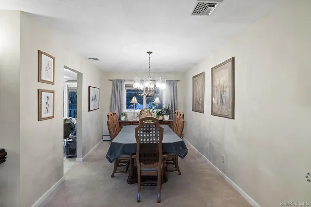 a view of a dining room with furniture and a chandelier