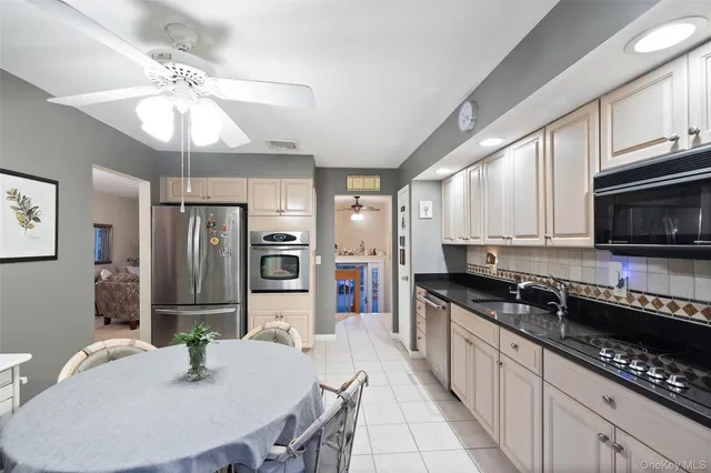 a kitchen with stainless steel appliances granite countertop a sink a stove cabinets and a refrigerator