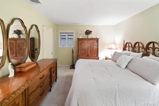 a bedroom with a bed and a dresser with mirror