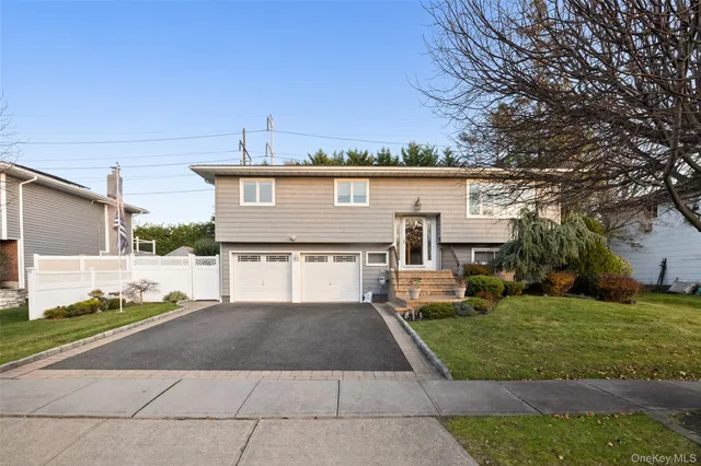 a view of a house with a yard and large tree