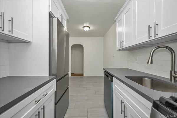 a view of a kitchen with a sink and refrigerator