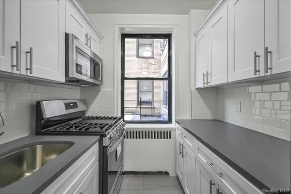 a kitchen with granite countertop a refrigerator and a sink