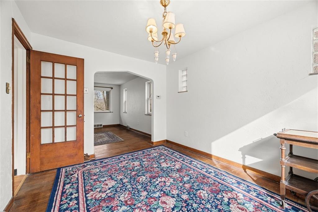 7210 Raymond Street Pittsburgh, PA 15218 - Photo 9 of 37 a view of a hallway with wooden floor and a chandelier