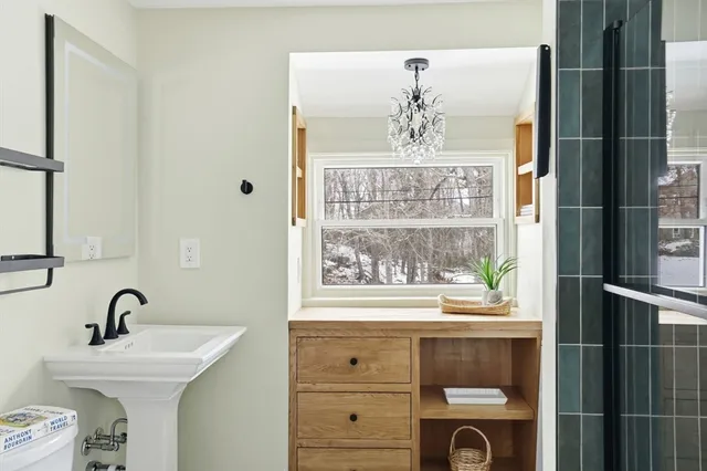 a bathroom with a sink a toilet and shower