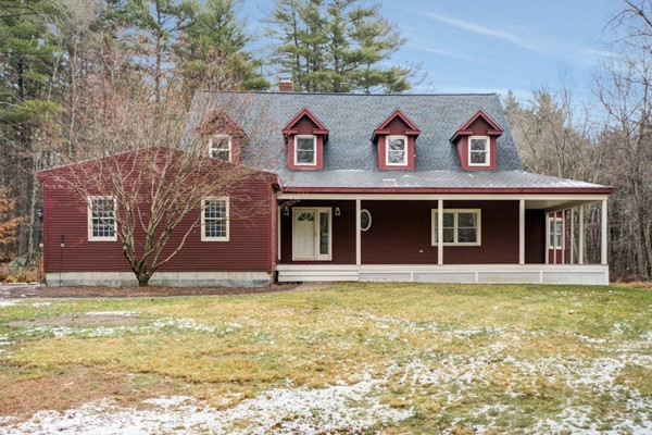 9 Crockett Road Upton, MA 01757 - Photo 1 of 22 a view of a brick house with large windows and a yard with plants and large trees