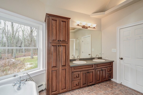 9 Crockett Road Upton, MA 01757 - Photo 16 of 22 a bathroom with a double vanity sink a mirror and a bathtub