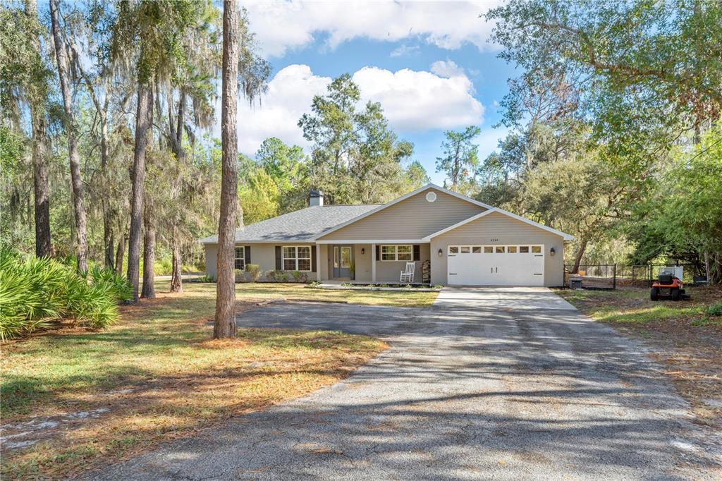 a front view of a house with a yard and trees