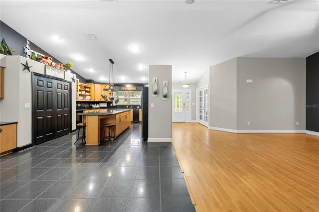 a kitchen with kitchen island granite countertop a sink a counter top space stainless steel appliances and cabinets