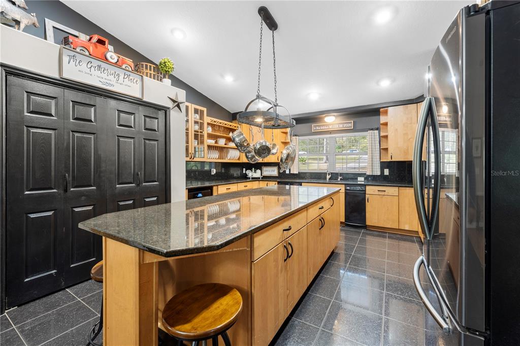 4244 Bessemer Road Brooksville, FL 34602 - Photo 12 of 56 a kitchen with kitchen island granite countertop a sink a counter top space stainless steel appliances and cabinets