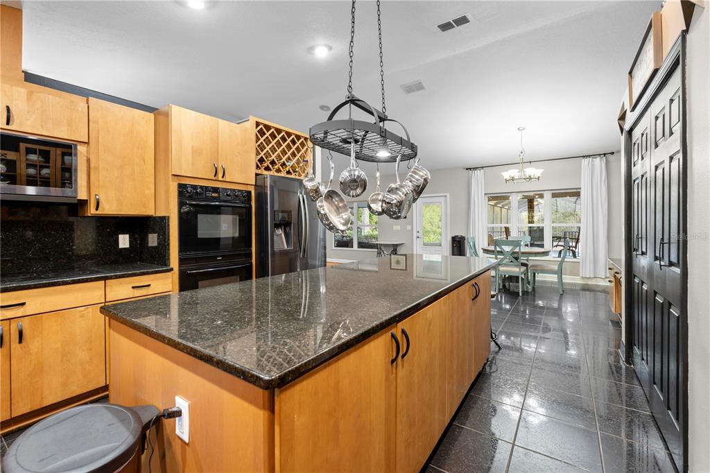 4244 Bessemer Road Brooksville, FL 34602 - Photo 16 of 56 a kitchen with stainless steel appliances granite countertop a sink a oven and a counter top space