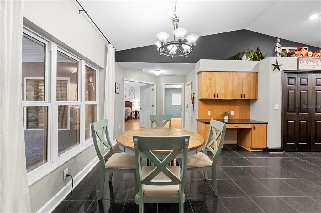 4244 Bessemer Road Brooksville, FL 34602 - Photo 23 of 56 a view of a dining room with furniture a chandelier and wooden floor