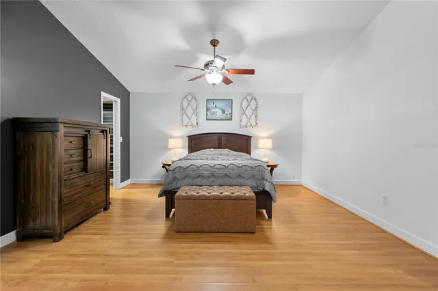 a bedroom with a large bed and wooden floor