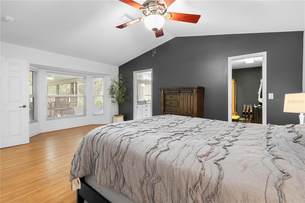 4244 Bessemer Road Brooksville, FL 34602 - Photo 27 of 56 a spacious bedroom with a large bed and chandelier