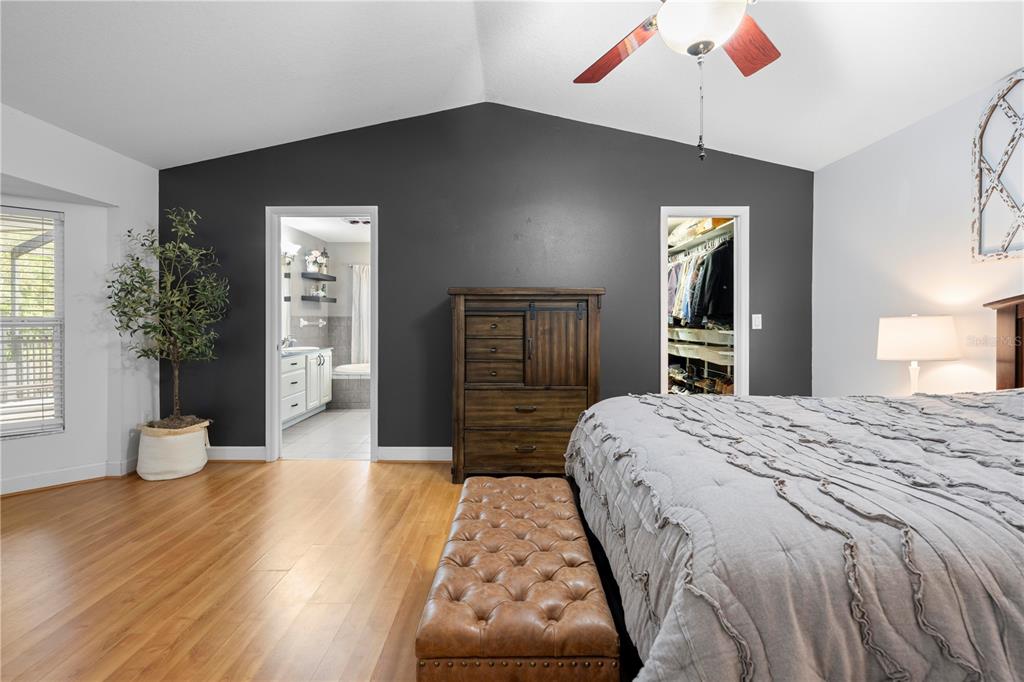 4244 Bessemer Road Brooksville, FL 34602 - Photo 28 of 56 a bedroom with a large bed and wooden floor