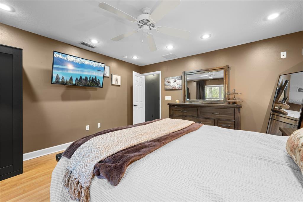 4244 Bessemer Road Brooksville, FL 34602 - Photo 37 of 56 a bedroom with a large bed and a chandelier